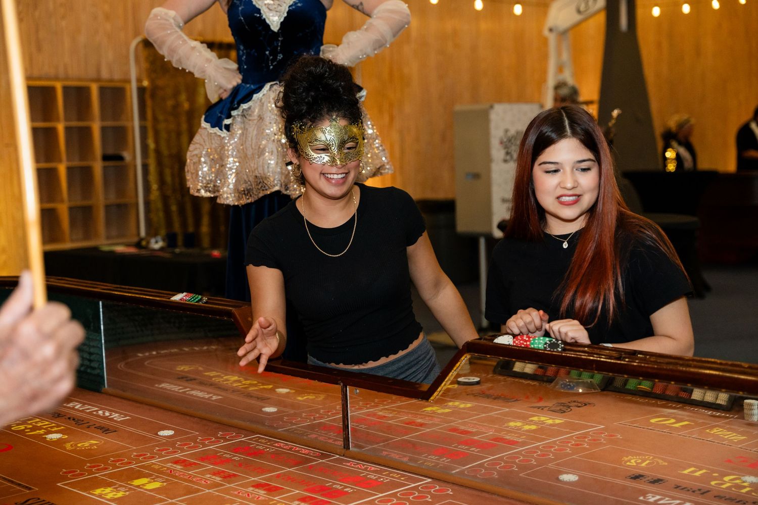 Casino dealers operating a roulette table at a themed gaming event.