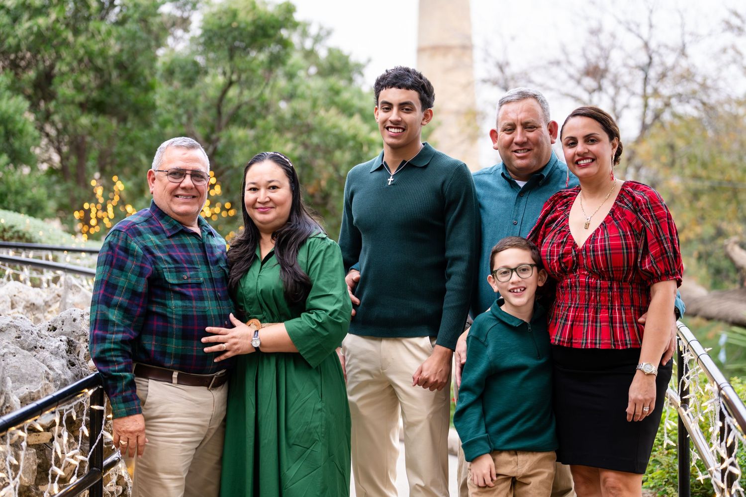 A collection of outdoor family portraits shows people wearing coordinated green and red outfits against natural backgrounds.