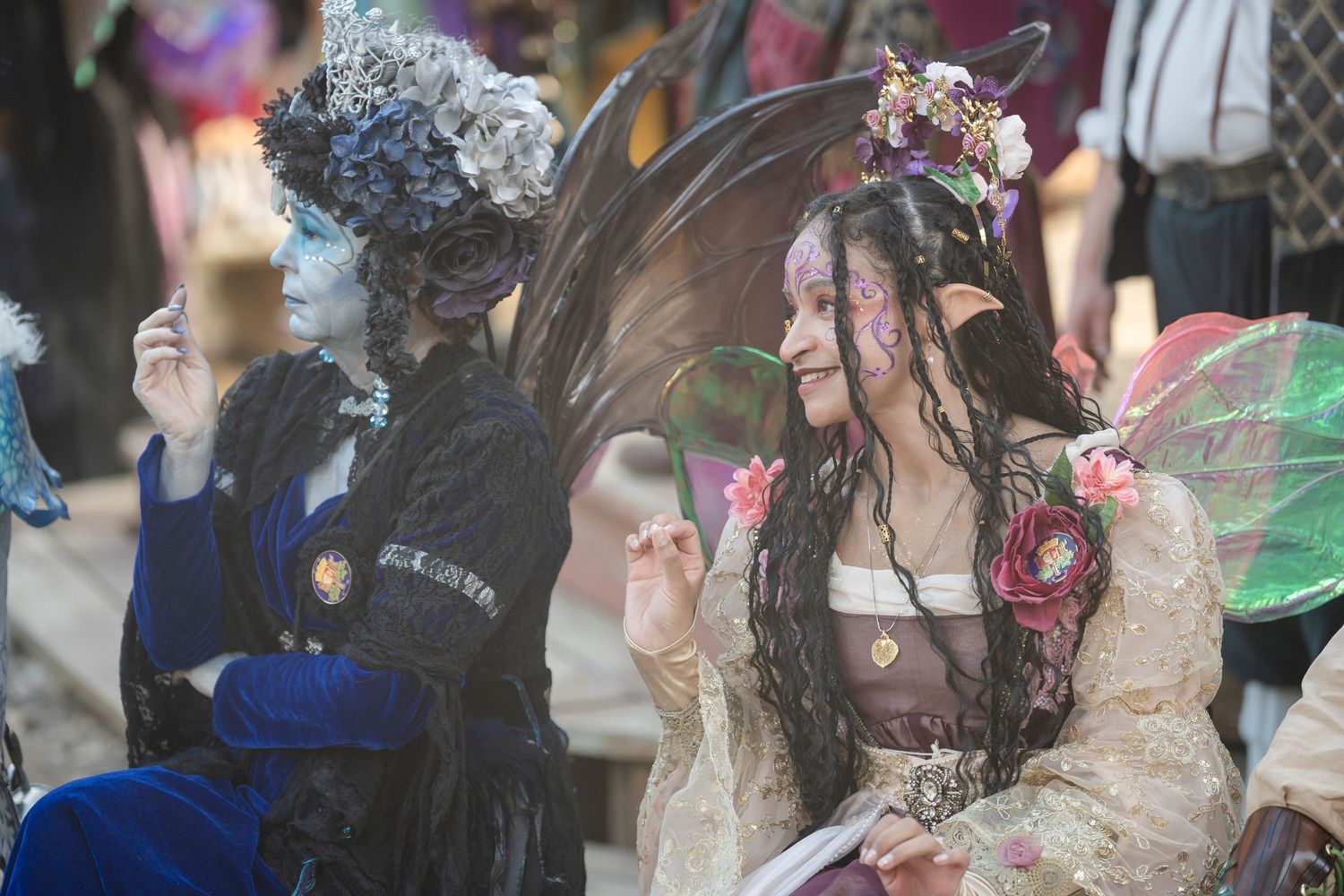 A group of costumed performers interact with bubbles at an outdoor festival or event.