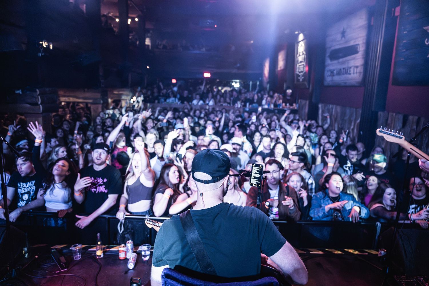 Crowded music venue with fans packed together during a high-energy performance.
