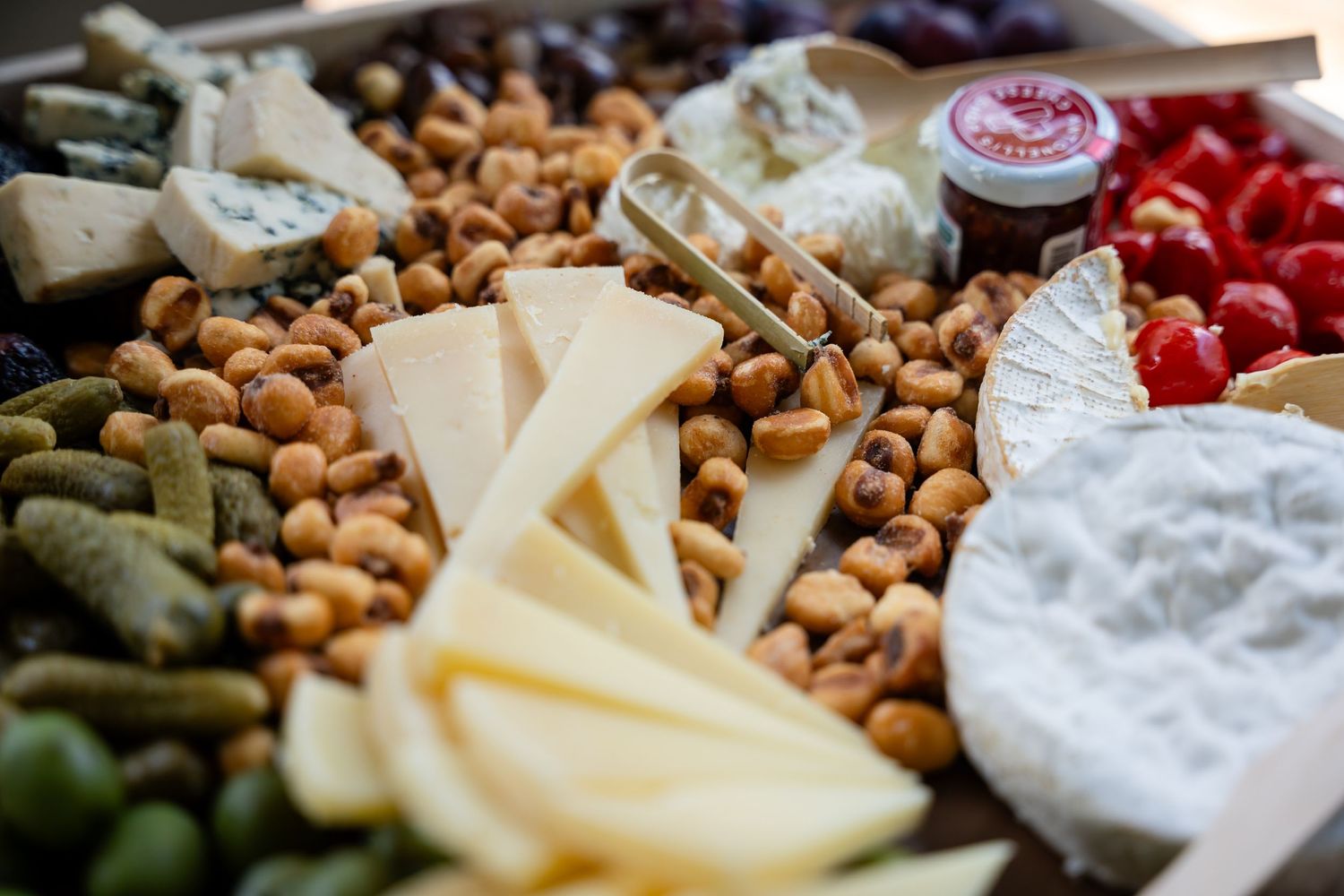 A gourmet cheese and charcuterie board with nuts, fresh fruit, and various cheeses.
