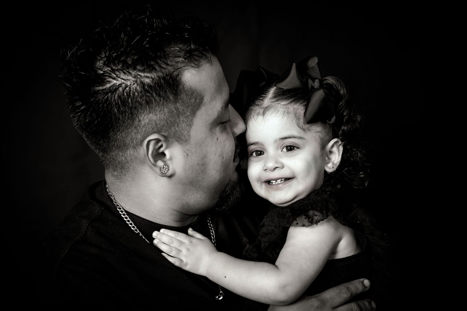 Candid black and white photograph capturing playful moment between parent and child.