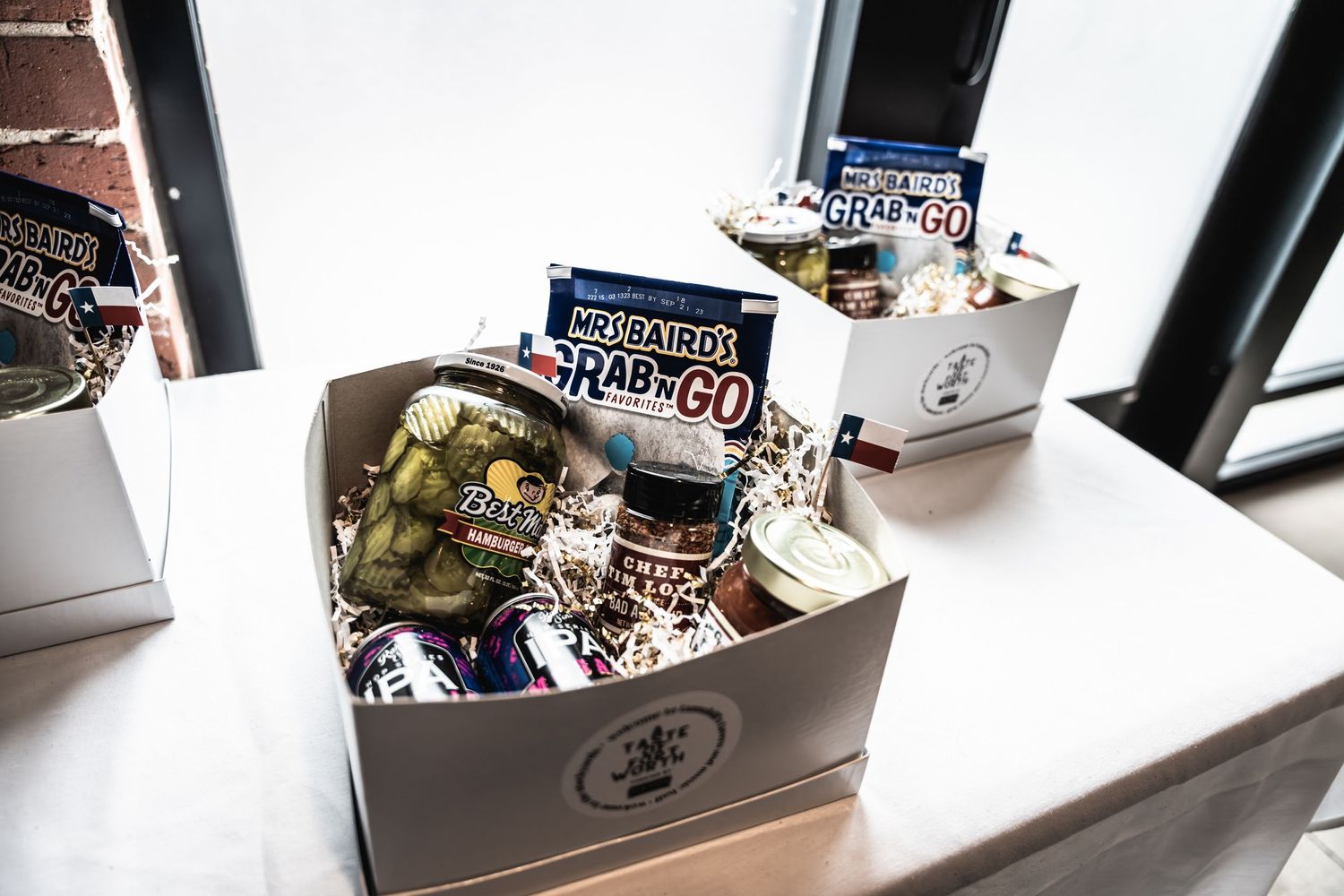 Promotional merchandise boxes filled with band items displayed on white surface.
