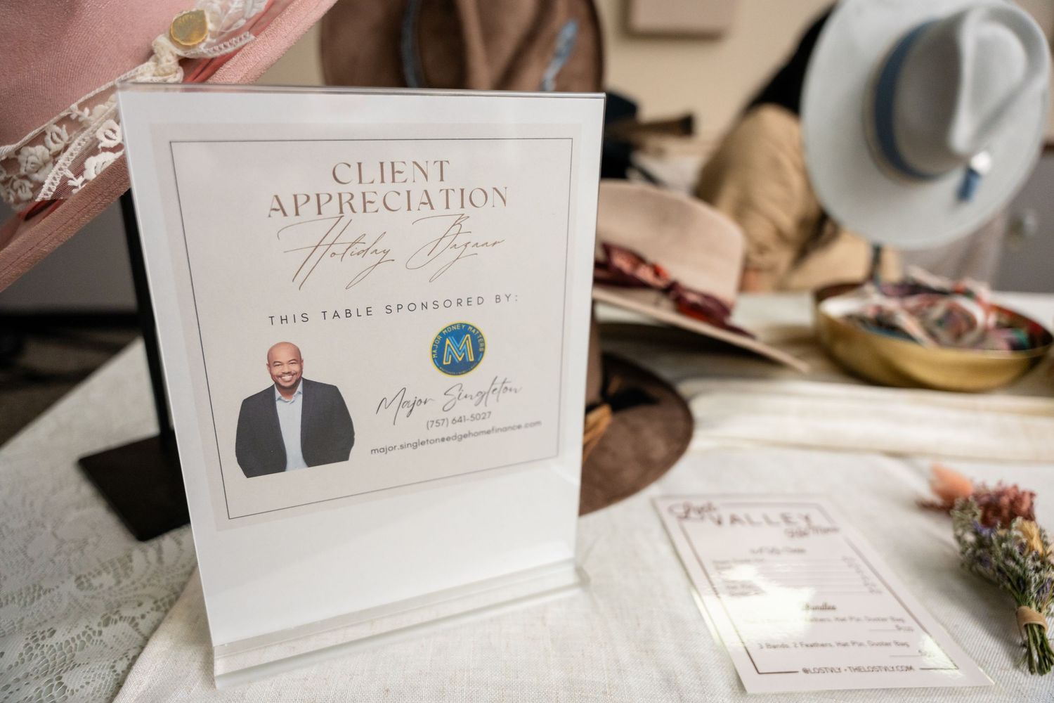 A client appreciation card and business materials arranged on a desk with decorative elements.