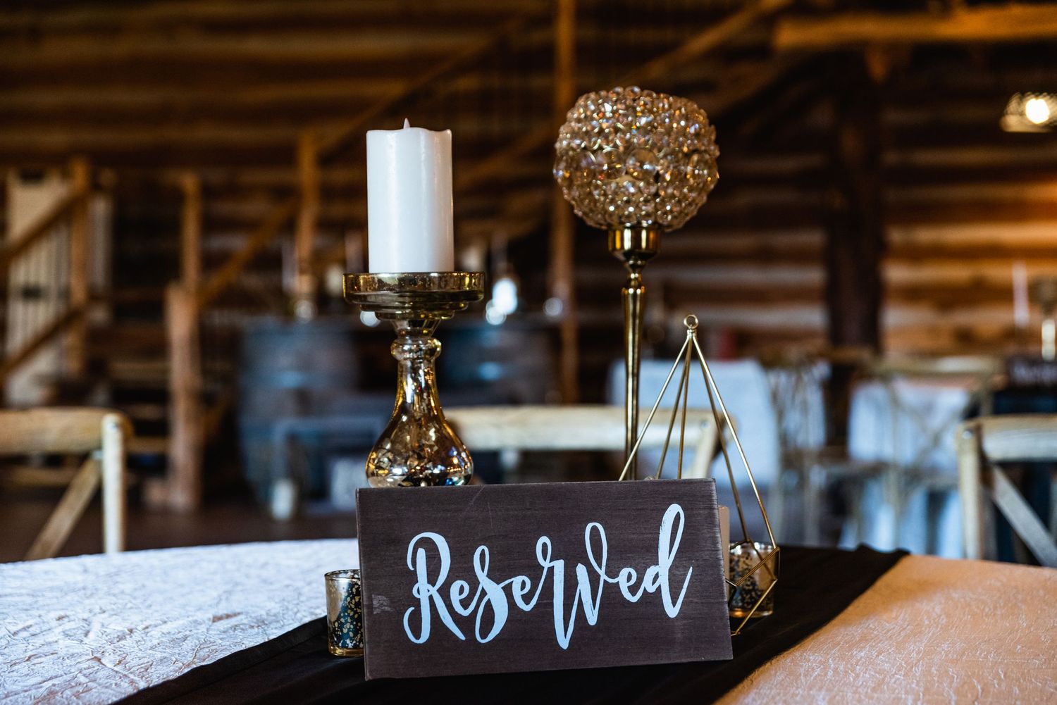A 'Reserved' sign with decorative candle holders on a white tablecloth.