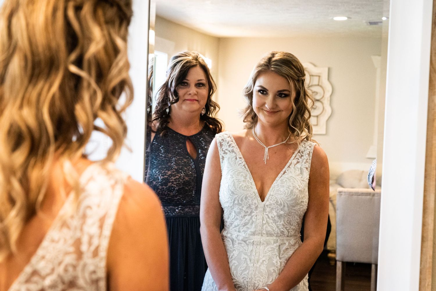 Reflection in mirror shows elegant white wedding dress during final preparations.