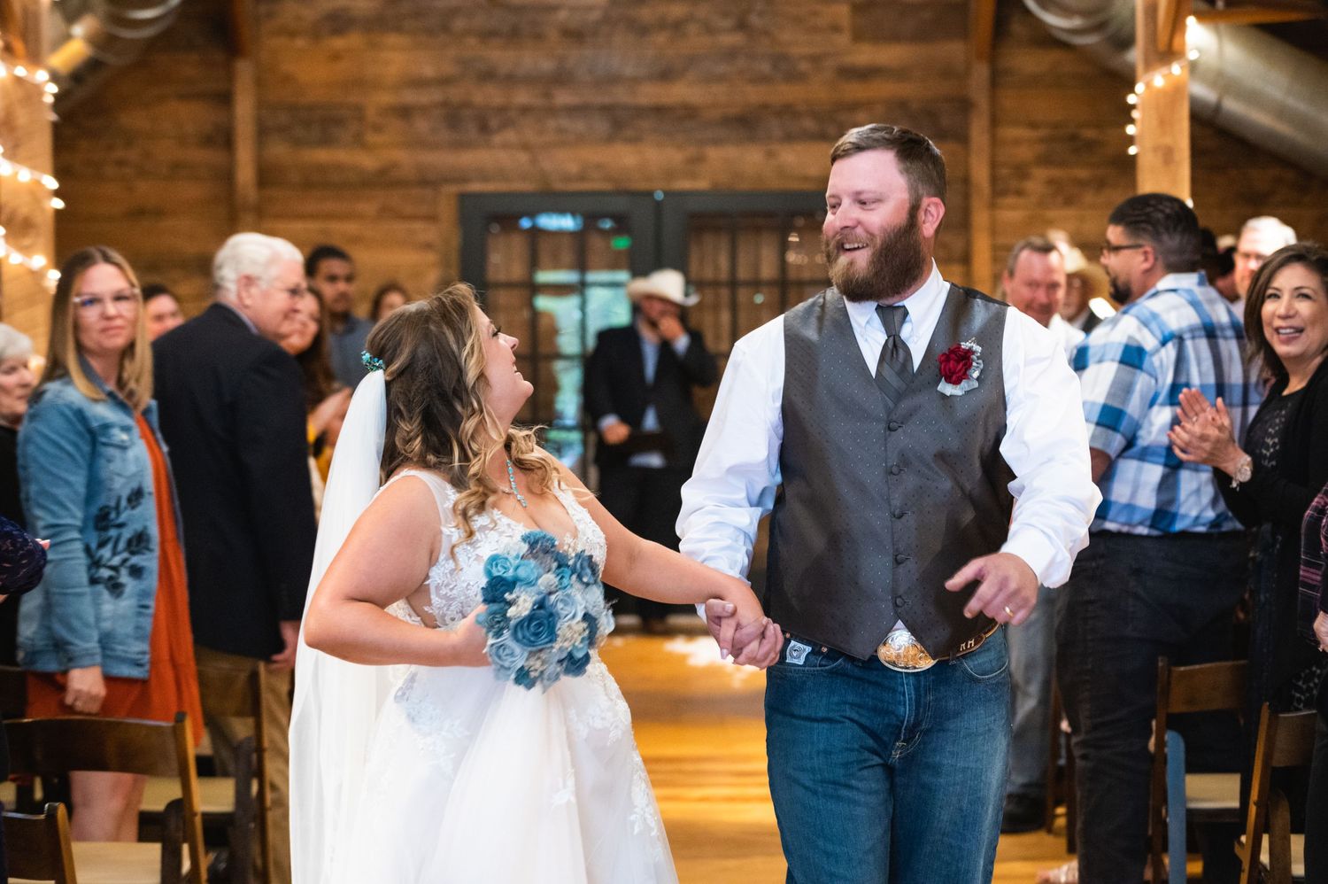 A couple shares a celebratory moment during their rustic barn wedding ceremony.