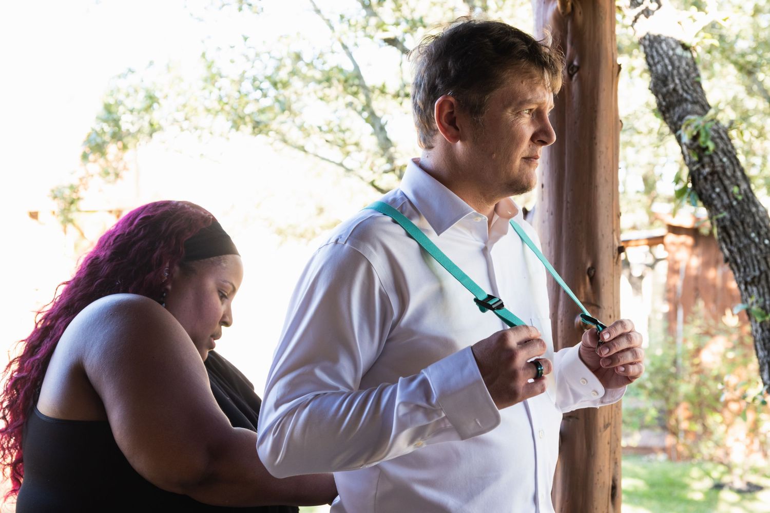 People prepare for event on outdoor porch with natural lighting.