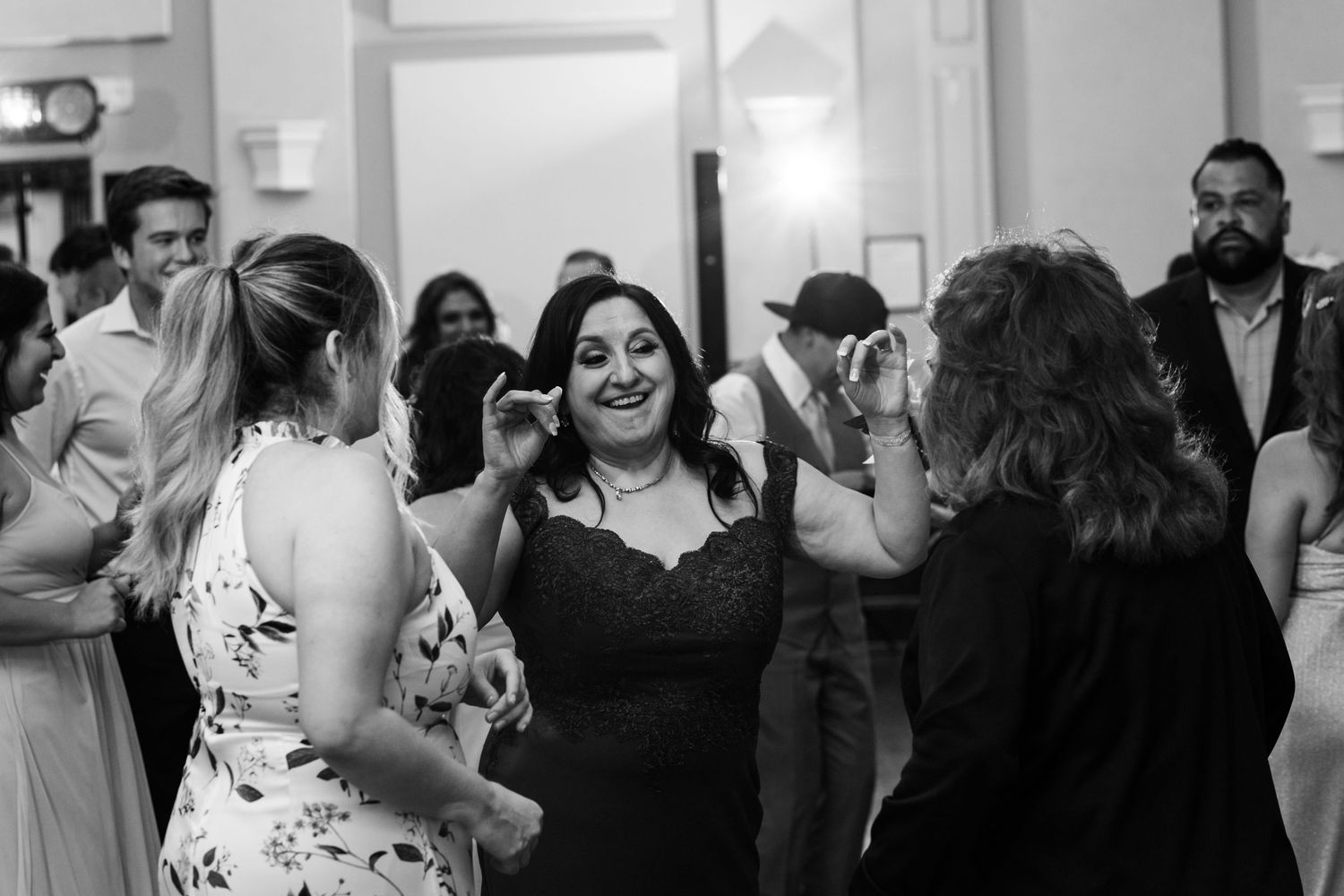 Guests enjoying themselves while dancing at an indoor wedding reception.