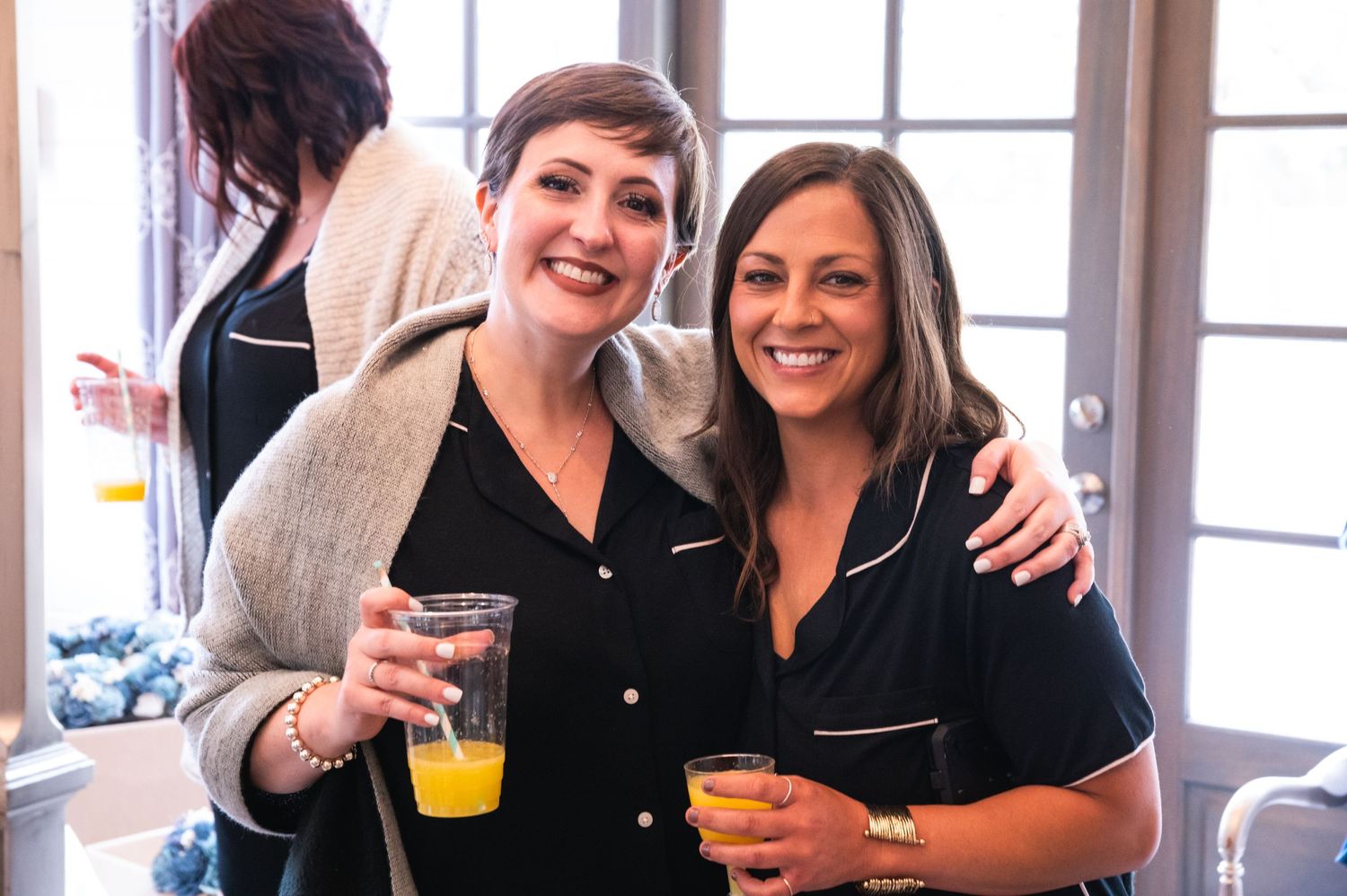 Two friends enjoying drinks together at a social gathering.