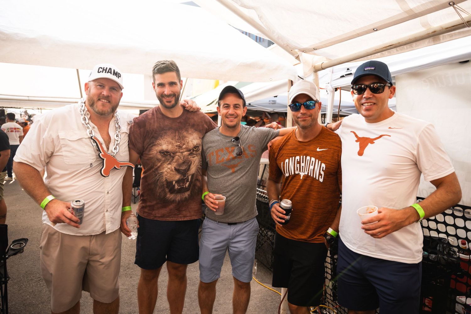 A group gathering under a white tent at an outdoor event.