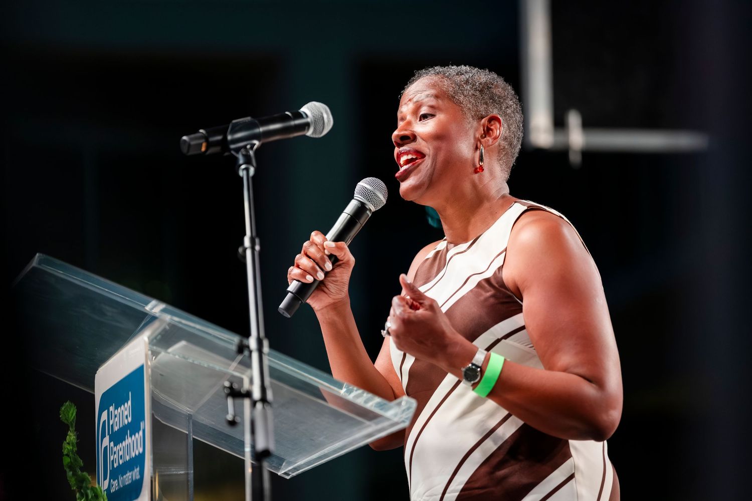 A performer sings passionately into a microphone on stage during a live musical performance.