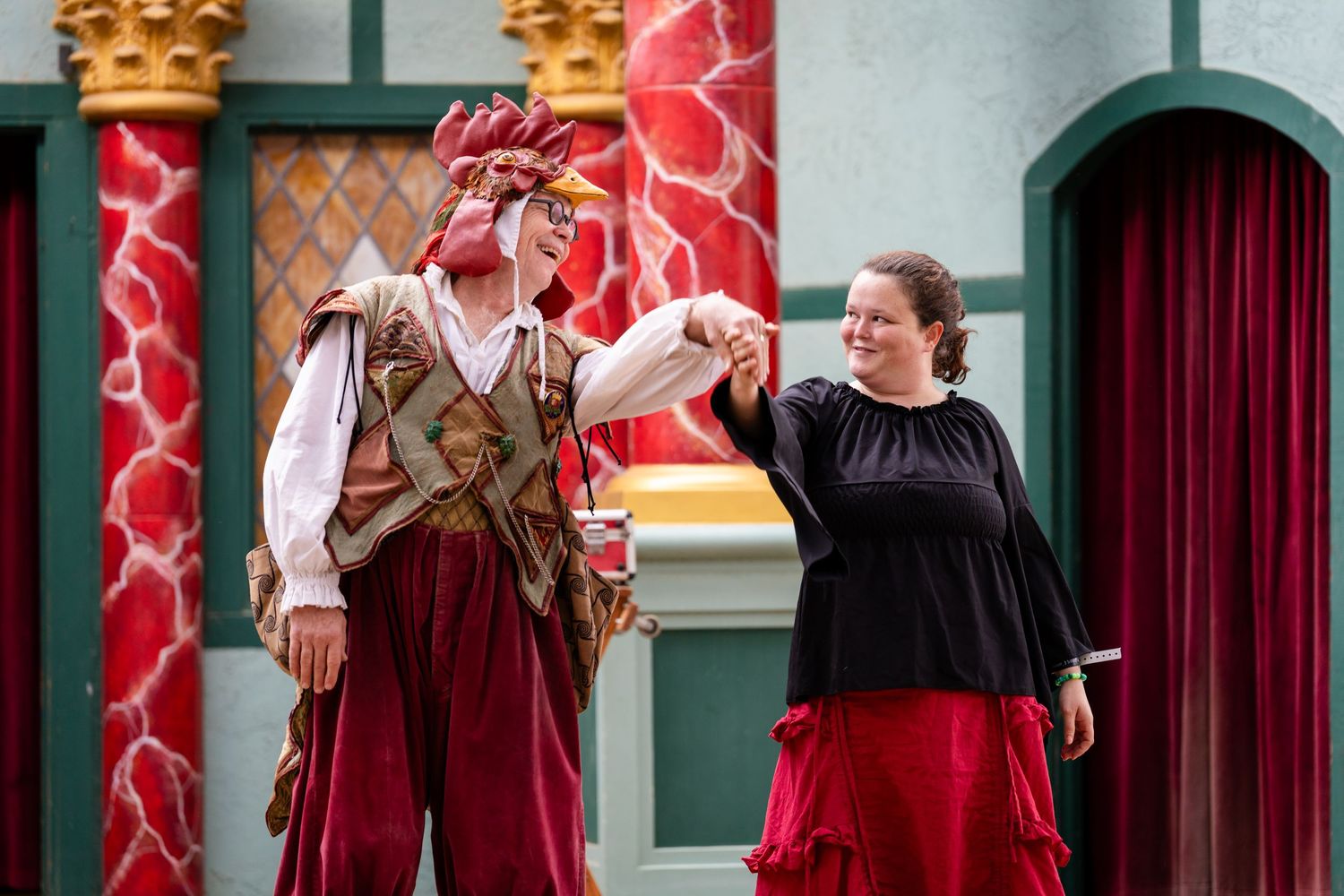 Medieval performers in period costumes entertain visitors at a historical reenactment event.