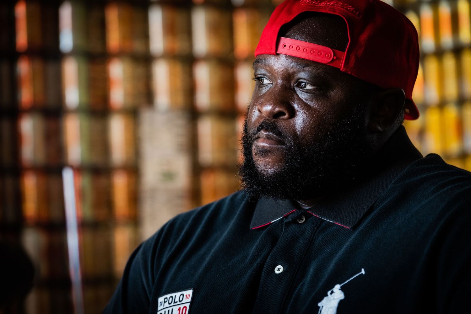 Portrait of man in red cap against blurred background of bookshelves.