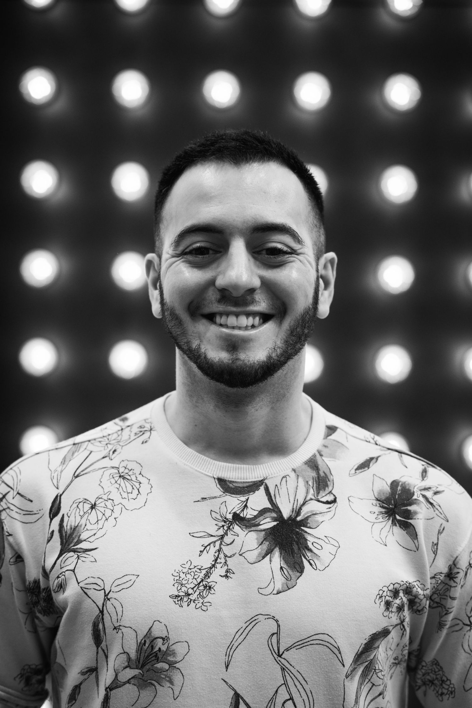 Black and white portrait with bokeh lights featuring a floral patterned t-shirt.