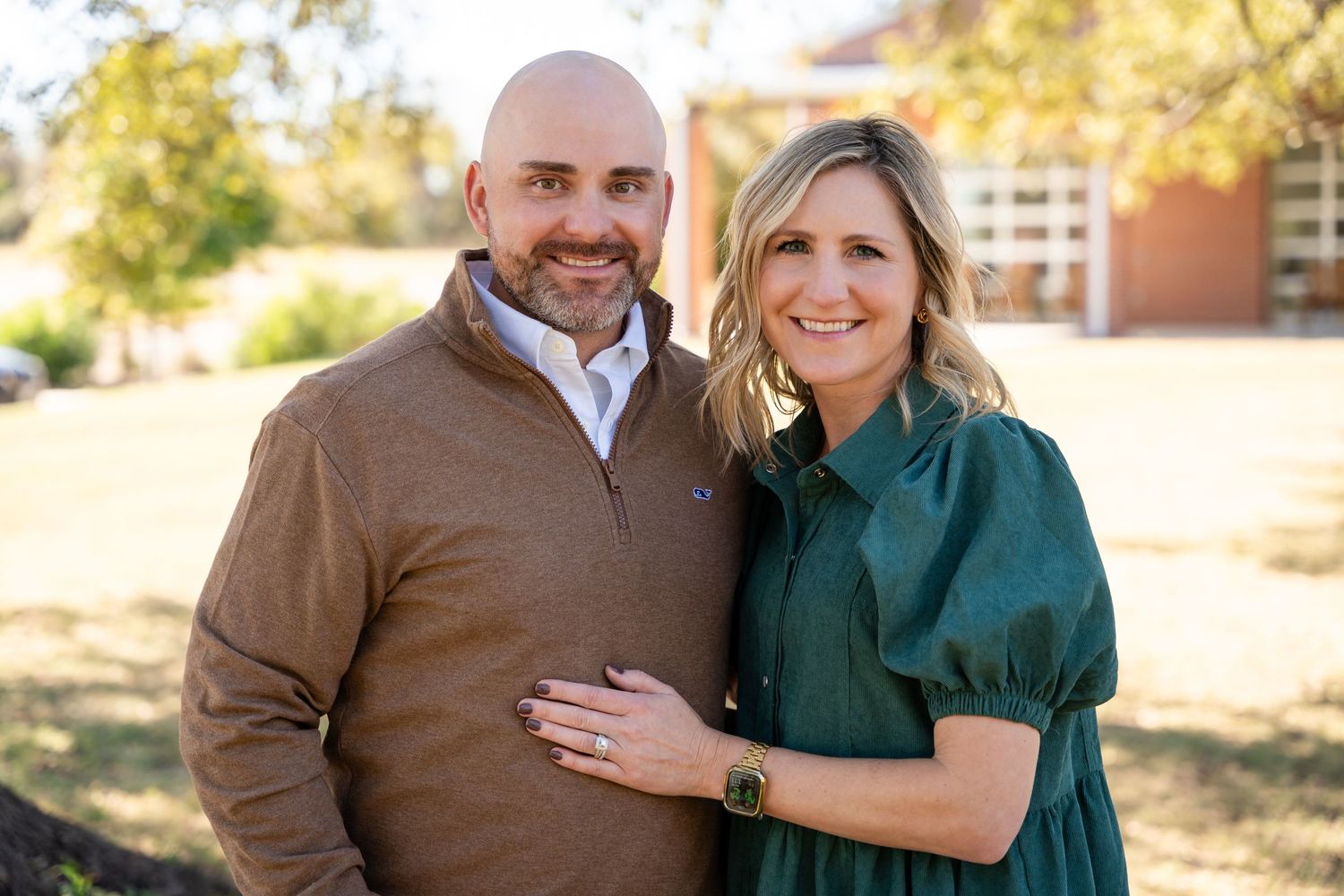 Couple posing outdoors in autumn with warm lighting.