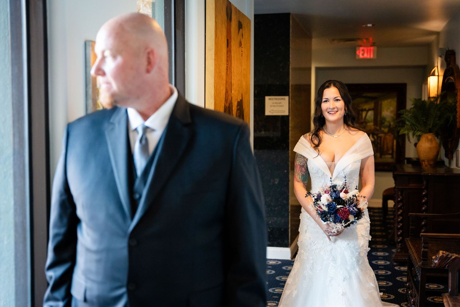 A touching first look moment between a couple in an elegant indoor setting.