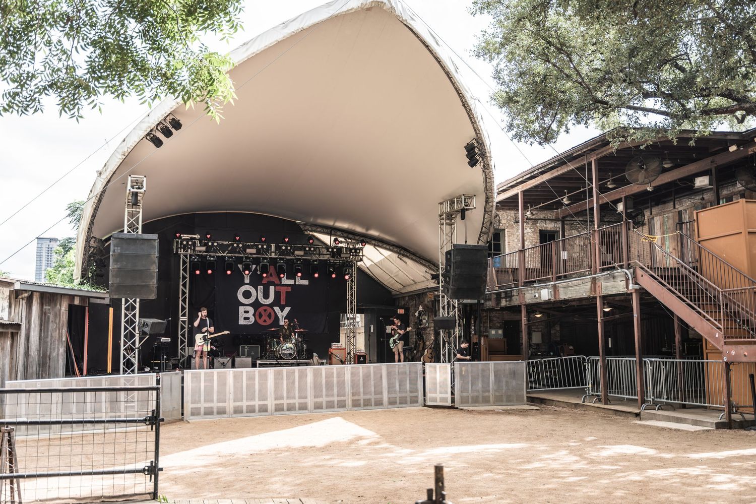 Outdoor amphitheater stage with curved white canopy at Stubb's BBQ music venue.