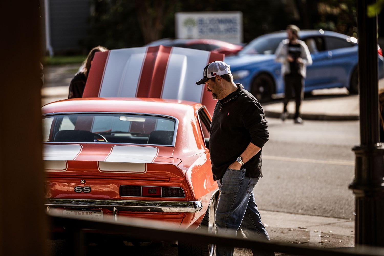 Classic red and white striped muscle car parked at an outdoor auto event.