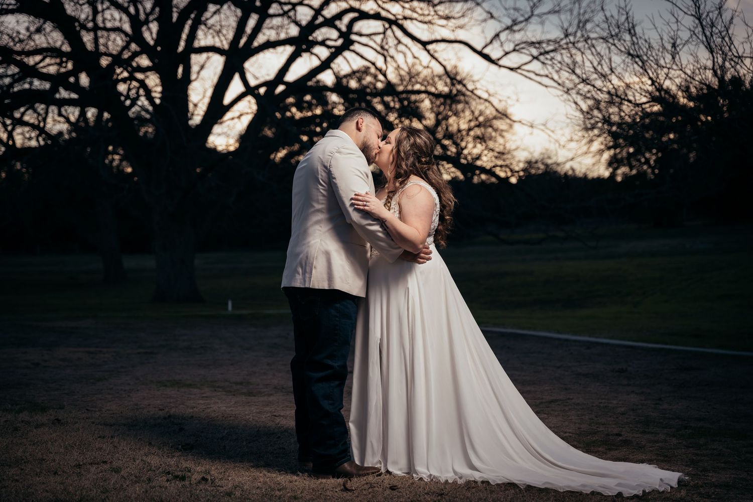 A couple shares a romantic moment at sunset during their wedding photoshoot.
