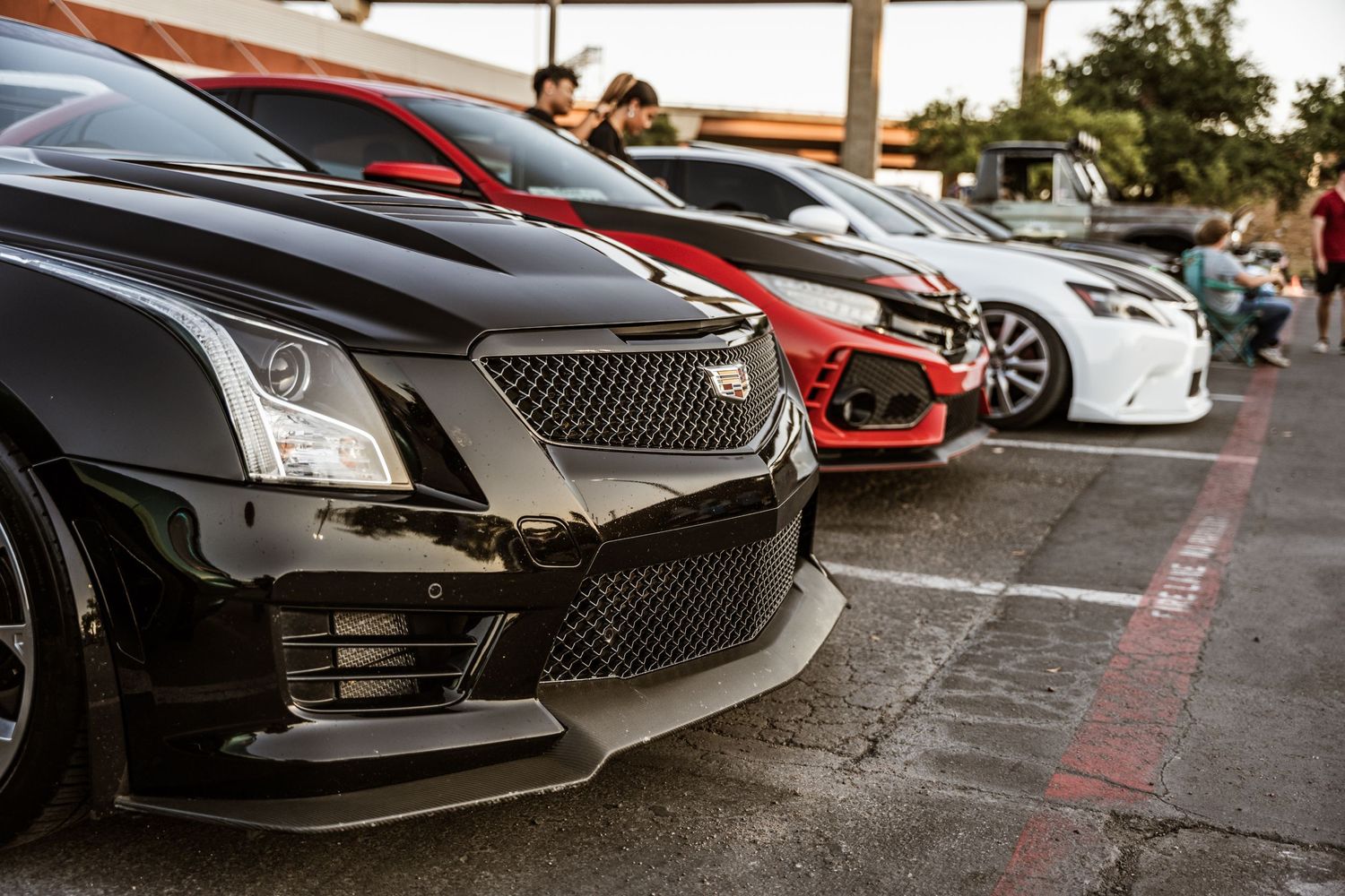 Front view of modern performance cars lined up showing aggressive grilles and bumpers.