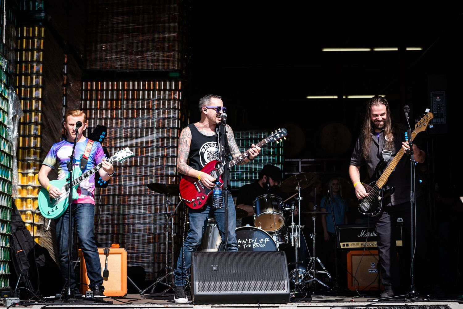 A rock band performs on stage with guitars and amplifiers during a live concert.