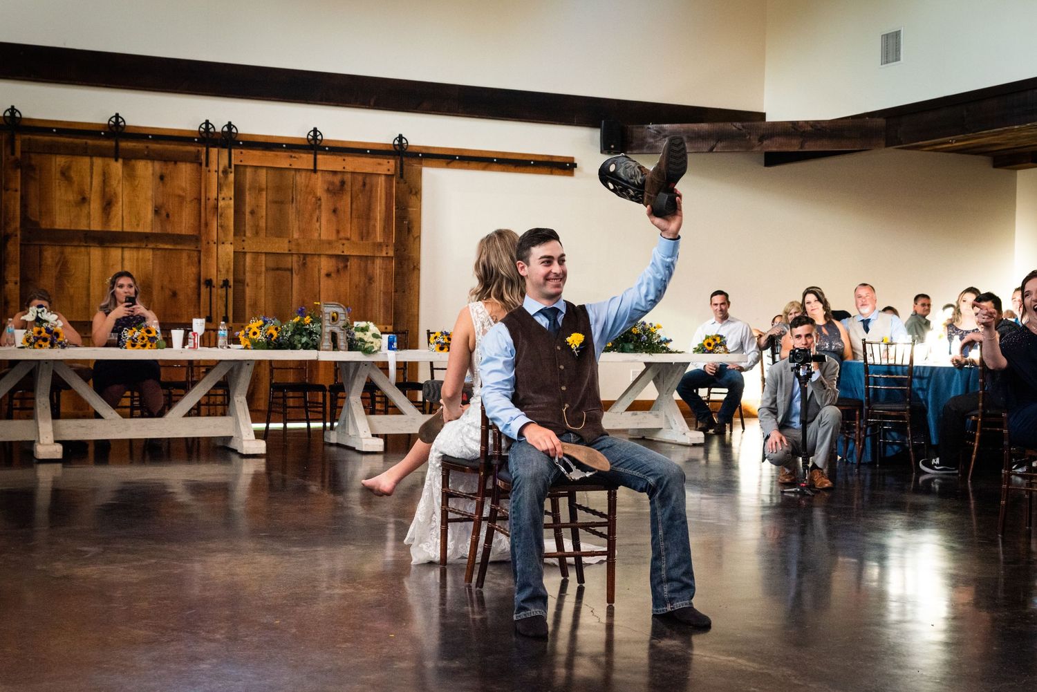 Wedding party members perform a fun dance routine during the reception in a rustic barn venue.