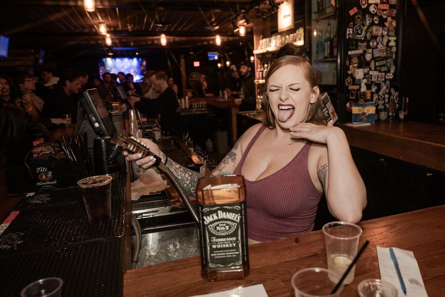 A sequence of photos showing someone enjoying drinks at a dimly lit bar with a bottle of Jack Daniel's whiskey visible.