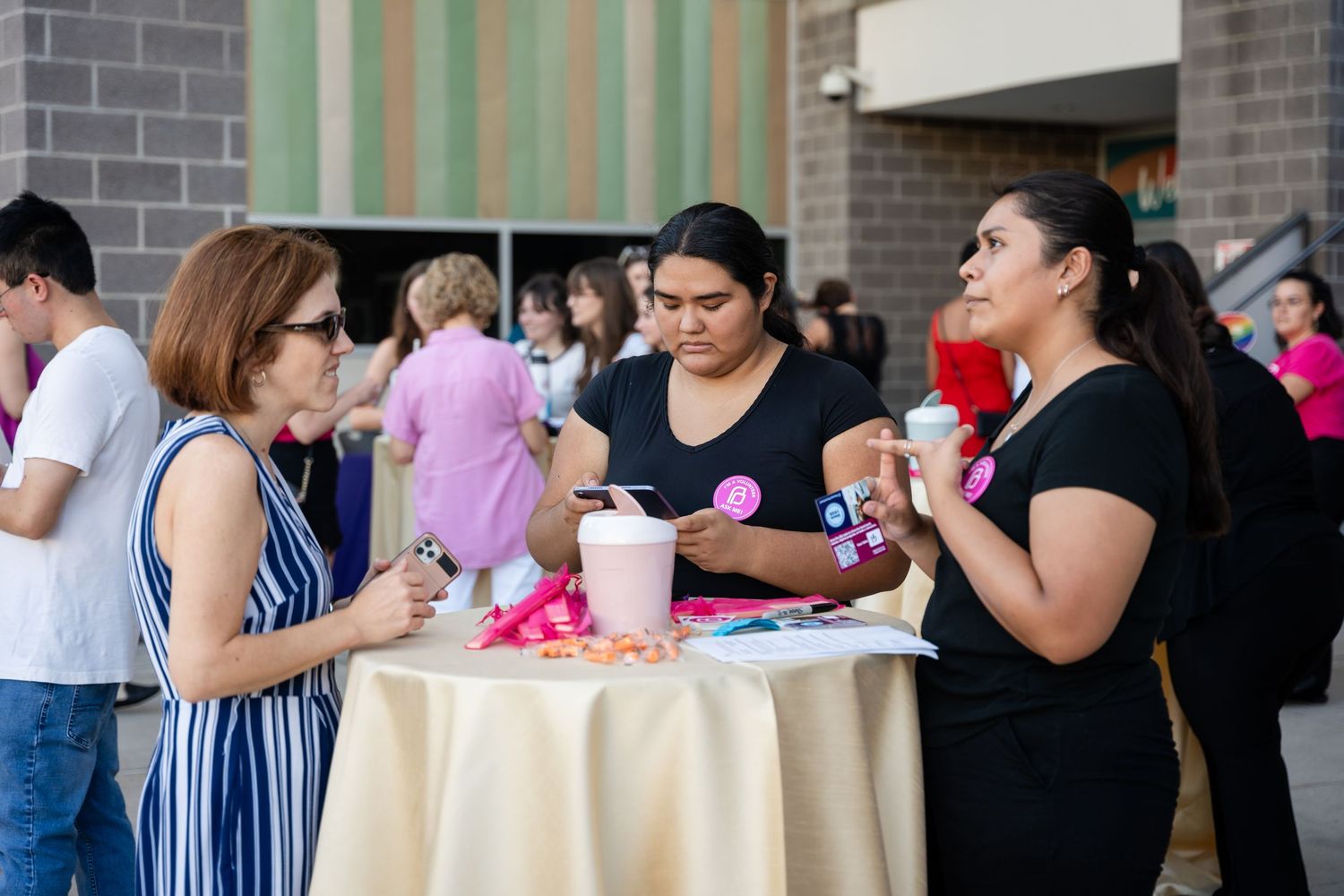 Guests chatting around high cocktail table at outdoor social gathering.