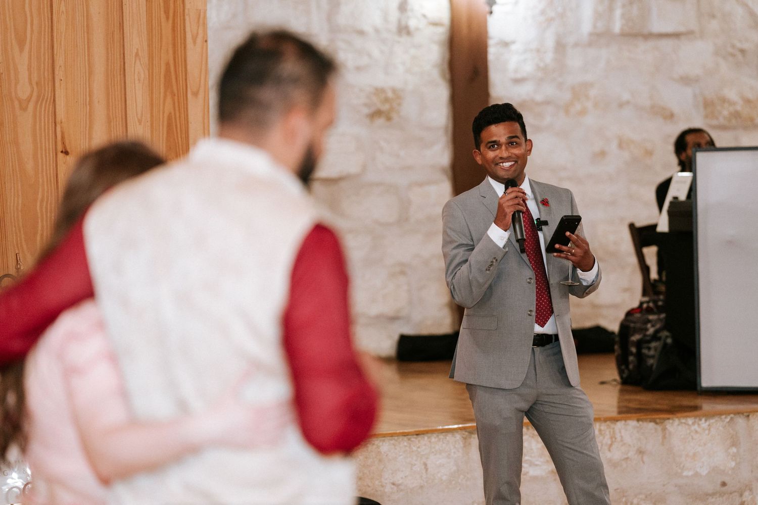 A photographer captures moments at an indoor wedding reception.