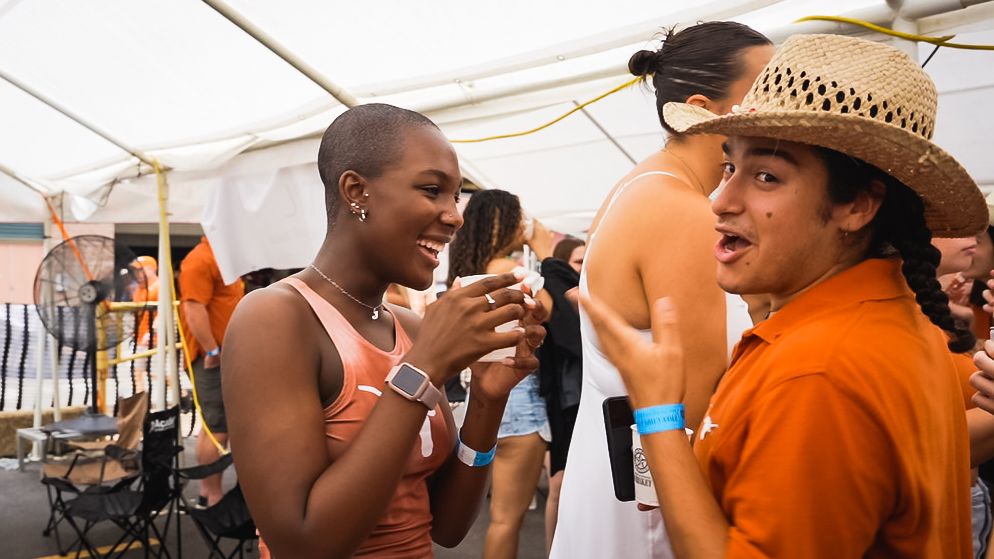 Attendees socializing at summer outdoor party wearing casual attire.