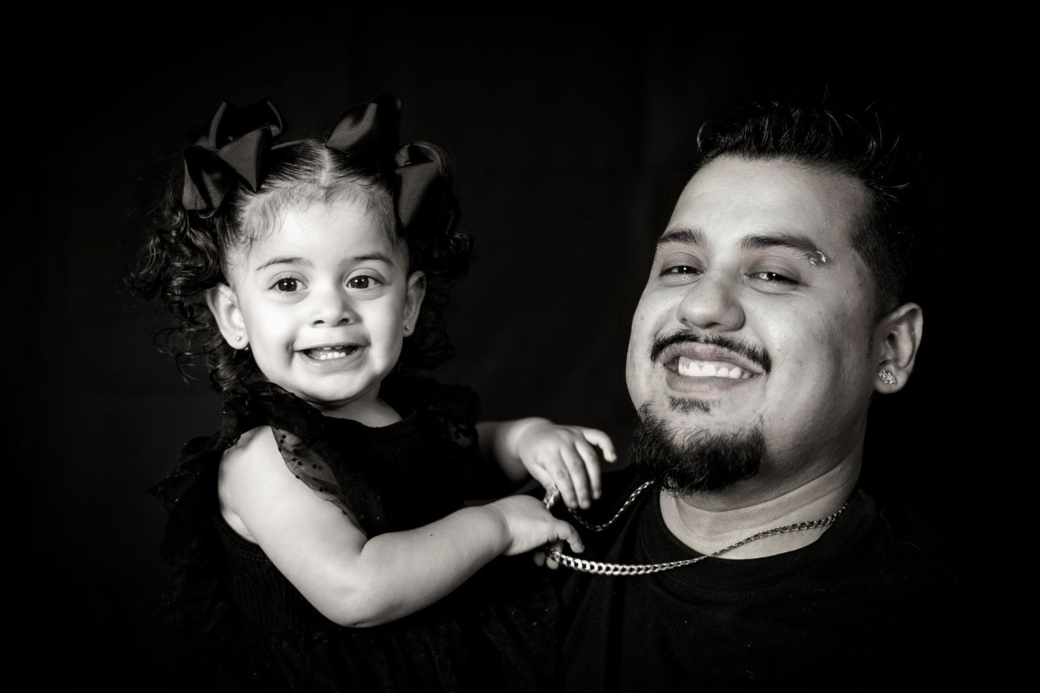 Black and white studio portrait showing happy parent and child interaction.