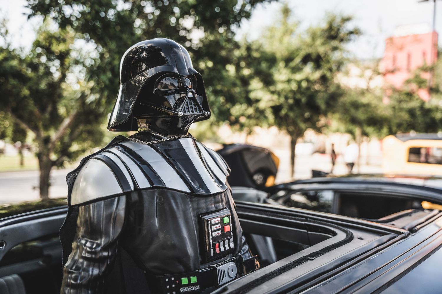 Darth Vader figure standing through car sunroof on display.