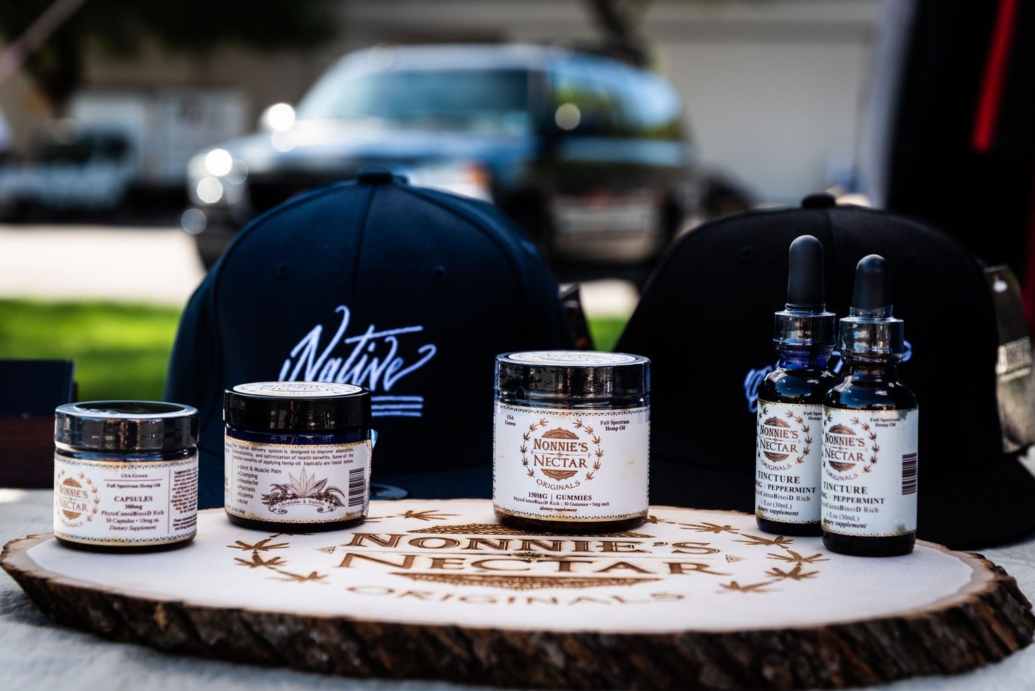 Collection of Carter's branded merchandise including hats and product jars on wooden surface.
