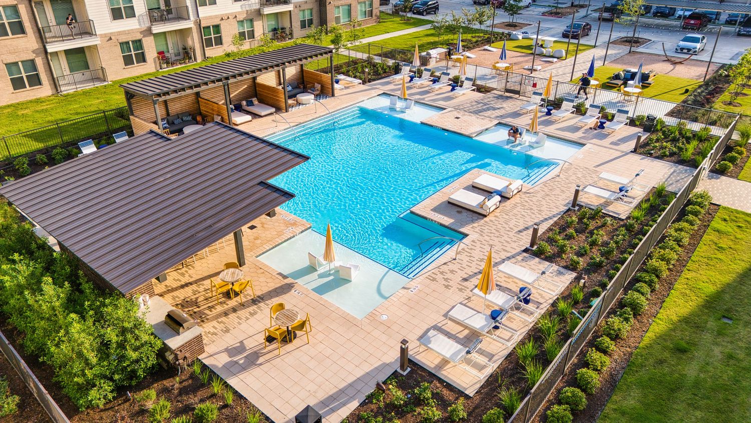 Resort-style pool area with covered pavilion and lounge chairs at luxury apartment community.