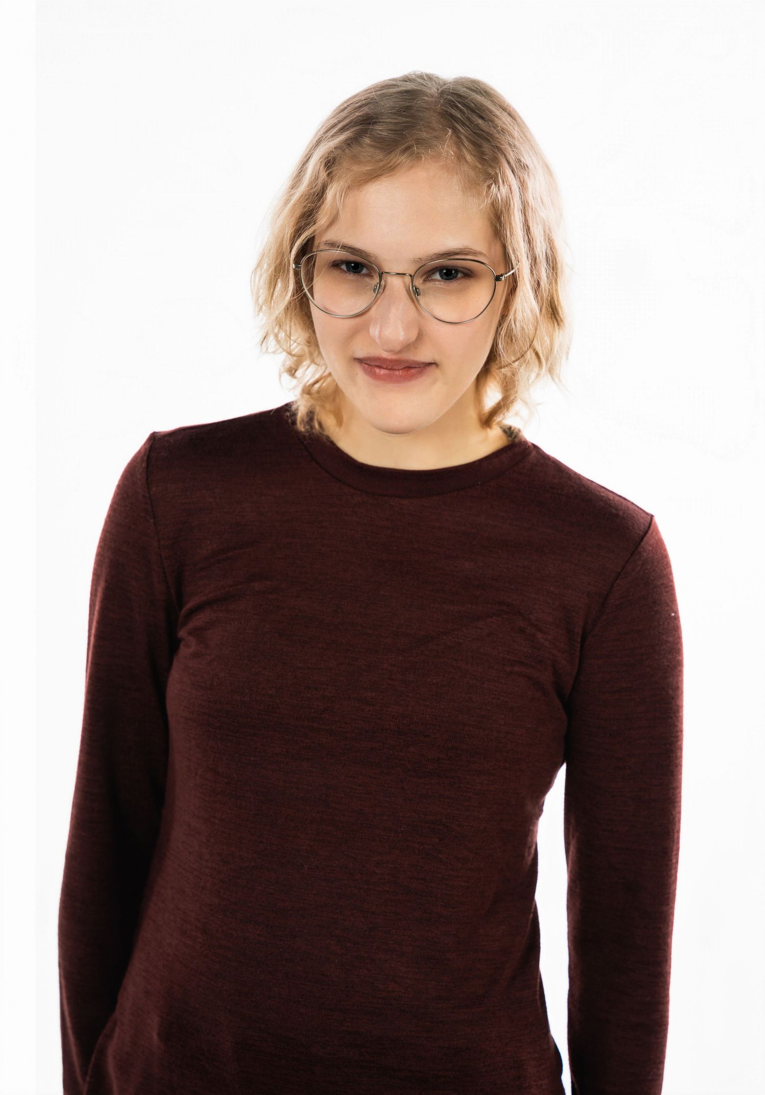 Portrait of person in burgundy sweater against white background with glasses.