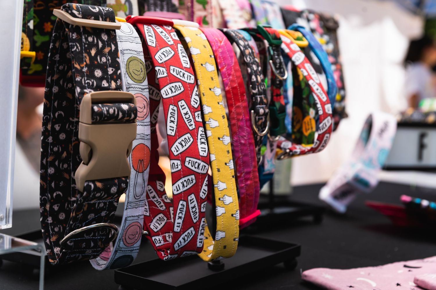 Dog collars with various patterns and prints arranged on display stand closeup view.