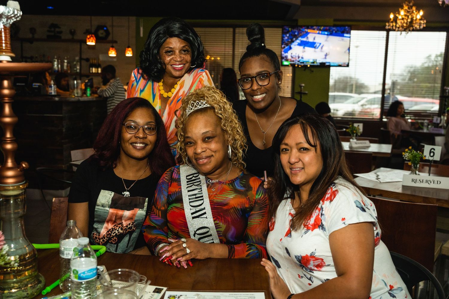 A group of friends enjoying drinks and conversation at a restaurant bar.