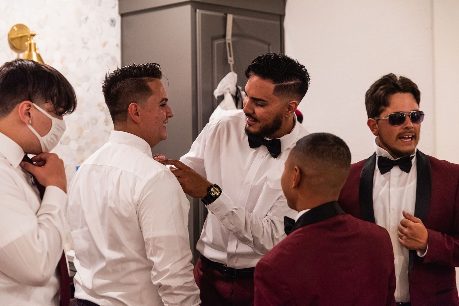 A group of formally dressed groomsmen getting ready for a wedding celebration.