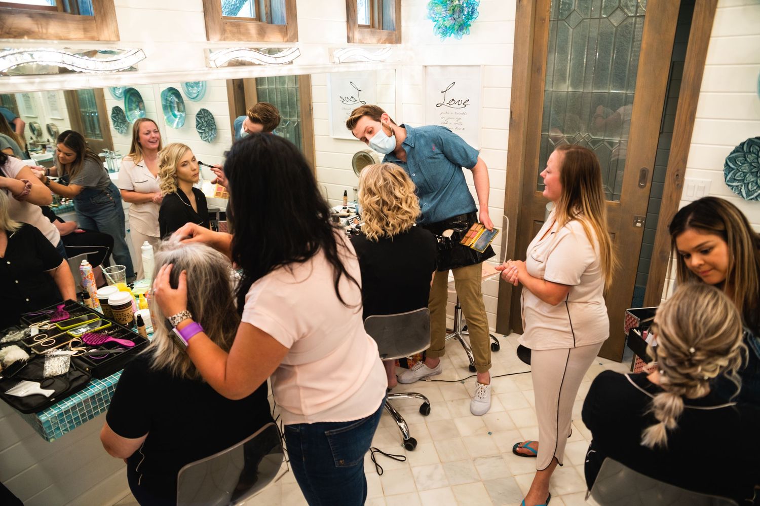 People mingling and socializing at an indoor event with teal wall decorations.