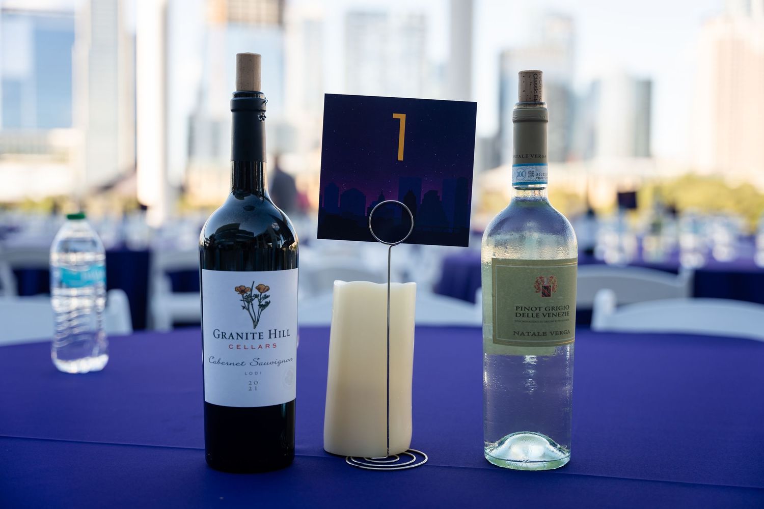 Wine bottles displayed on a blue tablecloth at an elegant event or tasting setup.