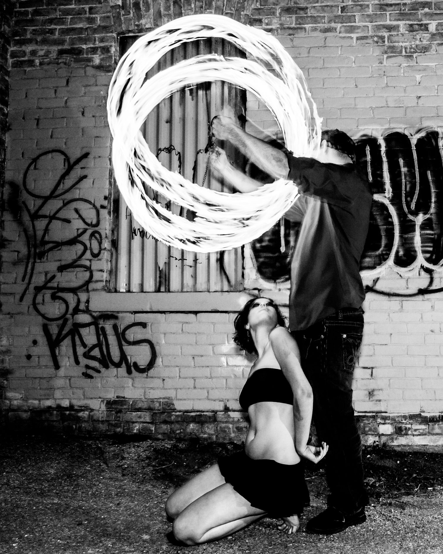 Light painting photography series showing glowing white circular patterns against dark brick walls with graffiti.