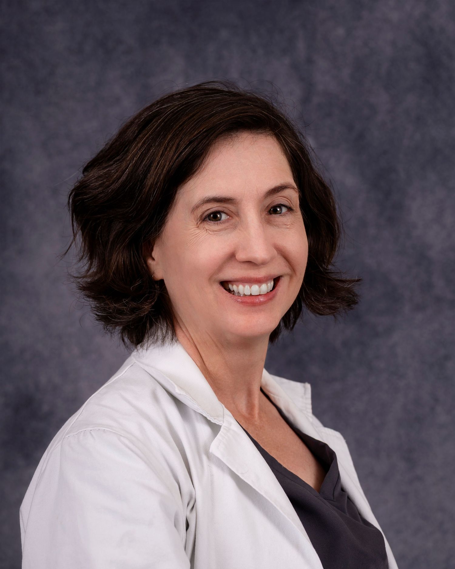 Portrait series showing different poses and expressions against a grey background wearing a white lab coat.