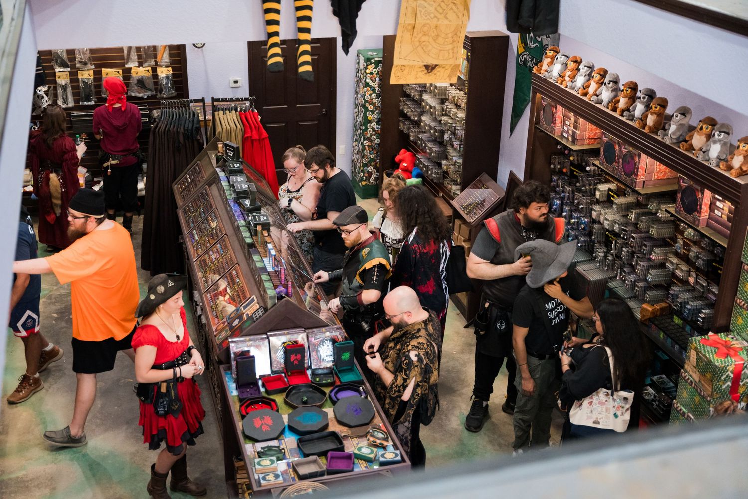 Overhead view of a busy marketplace filled with vendors and shoppers browsing medieval-style merchandise.