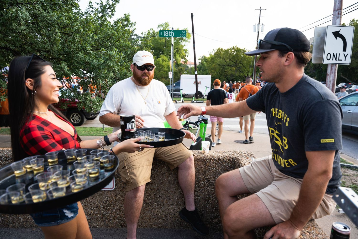 Food service staff interact with customers at an outdoor sports event.