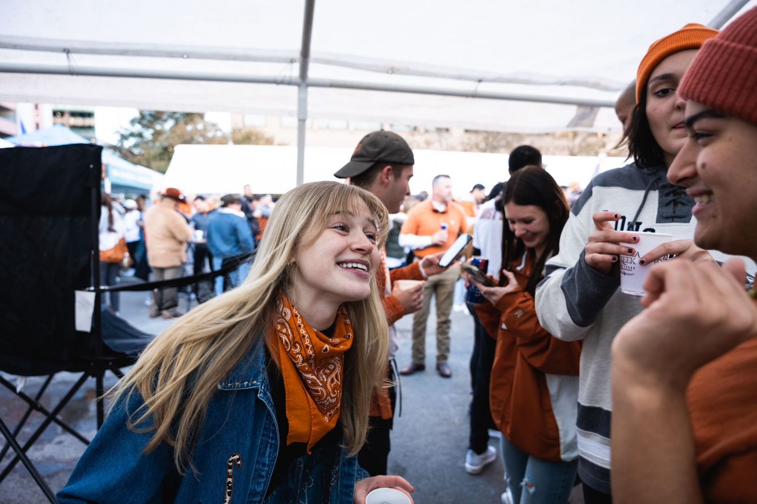 Enthusiastic crowd enjoying entertainment at outdoor tent party.
