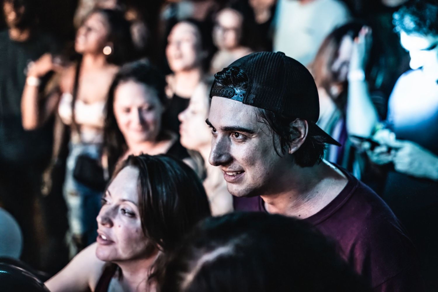 Concert attendees watching intently in the crowd during live performance.