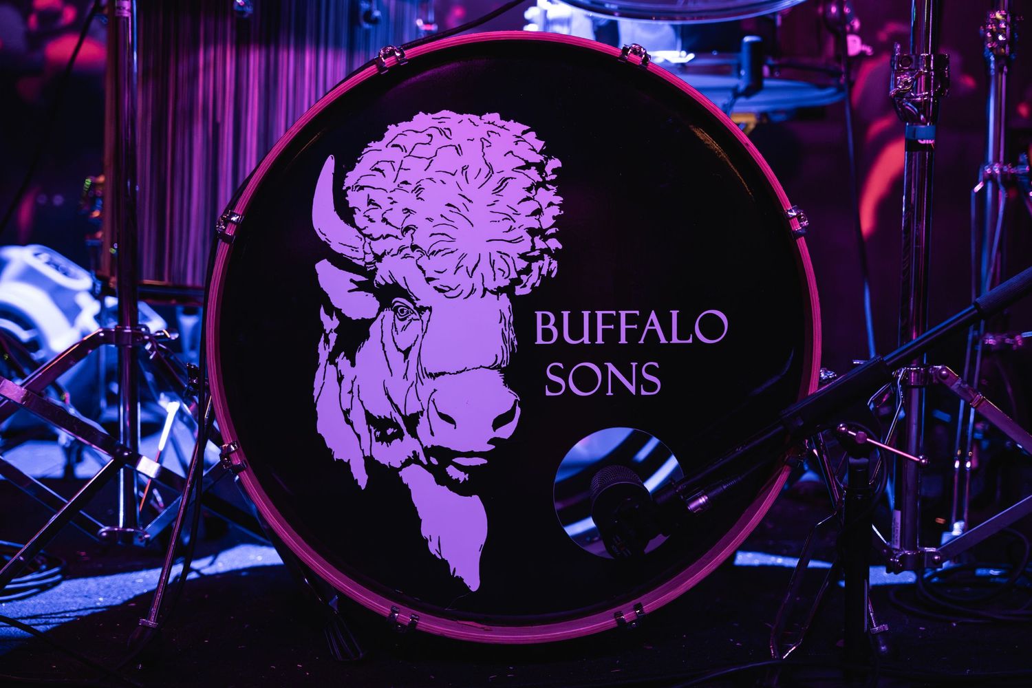 Buffalo Sons band logo illuminated on a drum kit on stage.