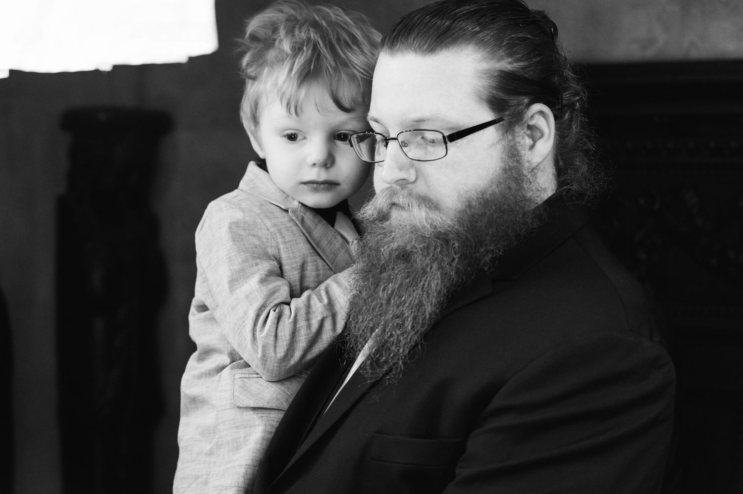 Black and white portrait showing tender moment between parent and child.