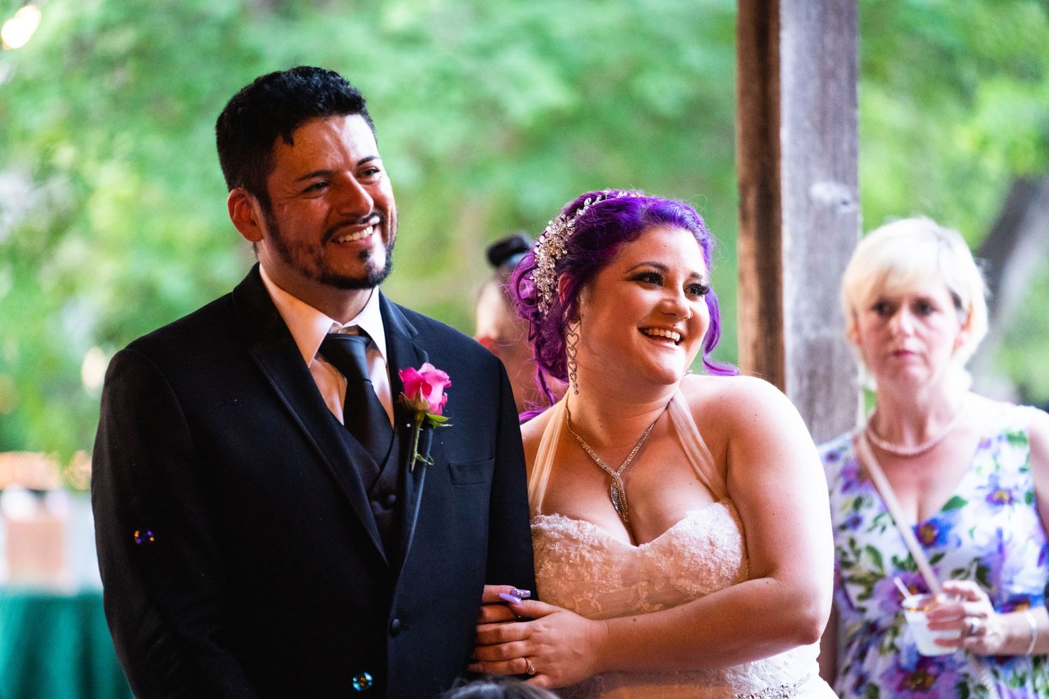 A joyful moment captured during a wedding celebration under a covered outdoor venue.